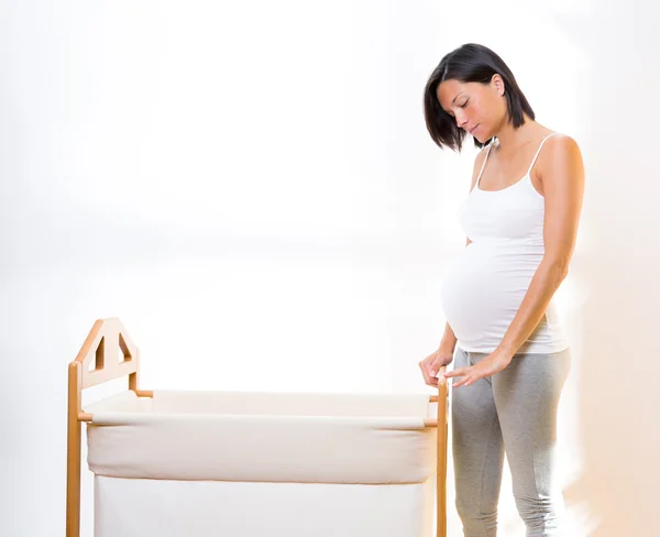 幼児用クレードルと夢を見て美しい妊娠中の女性 — ストック写真
