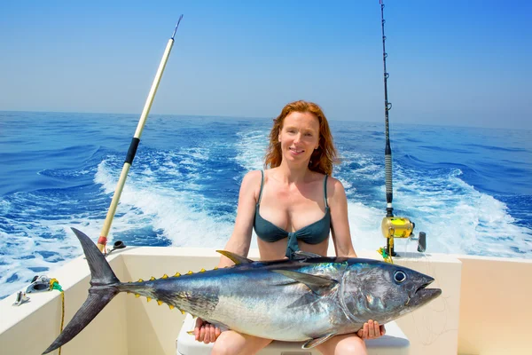 Bikini pescador mujer sosteniendo atún rojo en barco —  Fotos de Stock