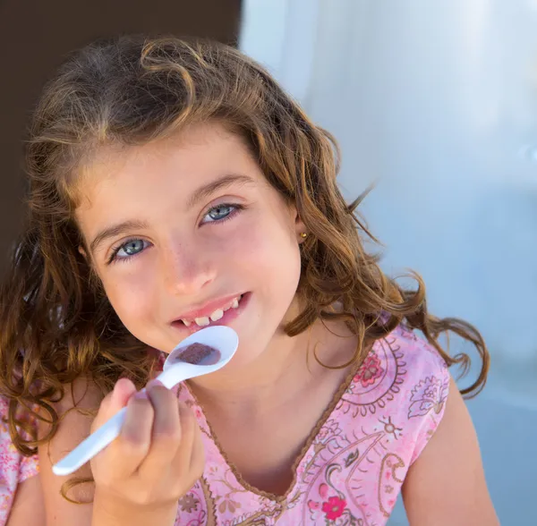 Blue eyes kid girl eating breakfast with spoon — Stock Photo, Image