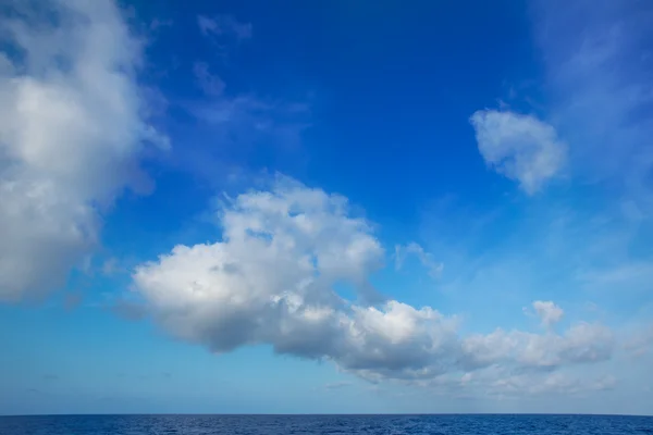Cumulus clouds in blue sky over water horizon — Stock Photo, Image