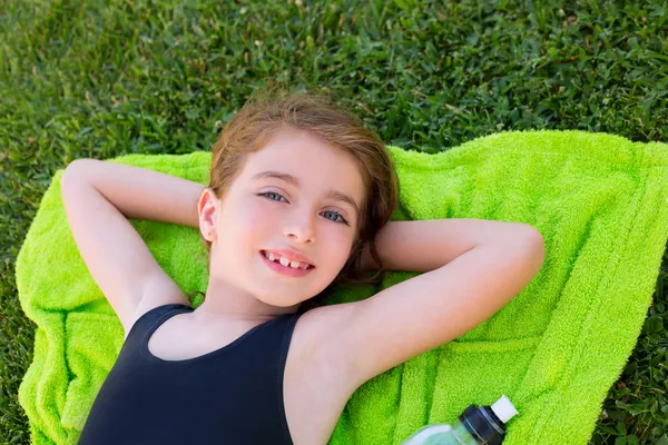 緑の芝生の上にタオルの上に横たわってリラックスした子供の女の子 — Stockfoto