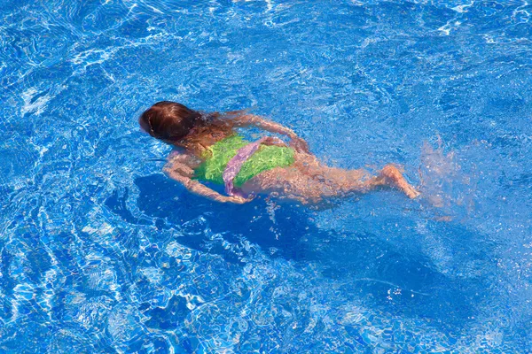 Crianças gilr natação subaquática na piscina azul — Fotografia de Stock