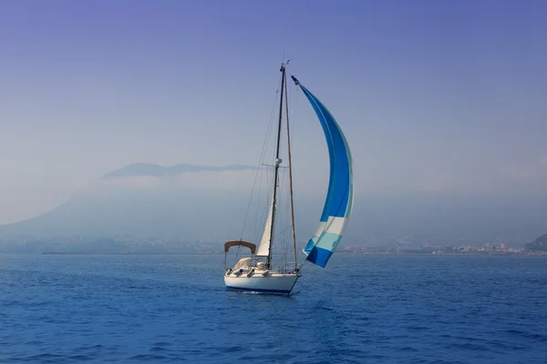 Γαλάζιο με ιστιοφόρο που πλέει σε μια ομίχλη ακτή — Φωτογραφία Αρχείου