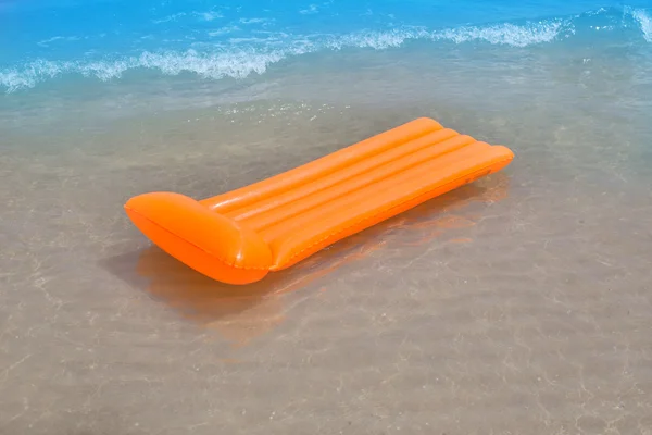 Ακτή παραλία με πορτοκαλί πλωτό σαλόνι και κύματα — Φωτογραφία Αρχείου