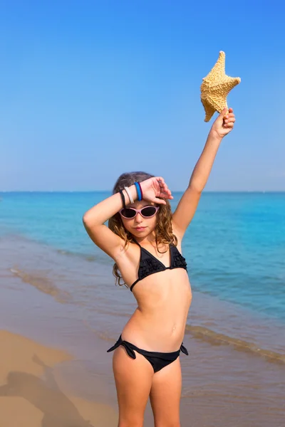 Menina praia azul com biquíni estrela do mar e óculos de sol — Fotografia de Stock