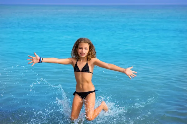 Blue beach kid girl with bikini jumping and running — Stock Photo, Image