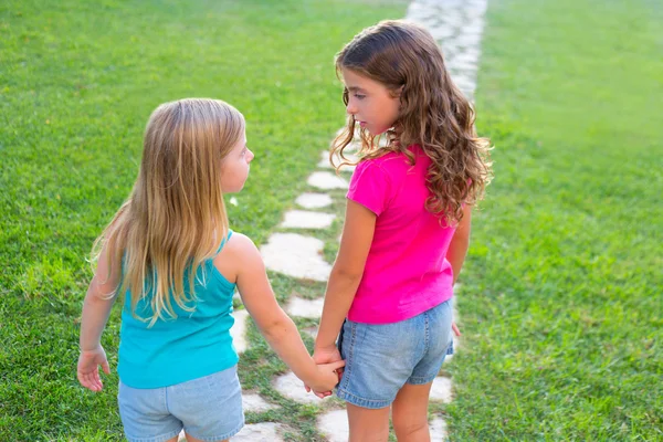 Vrienden zus meisjes samen in gras tuin spoor — Stockfoto