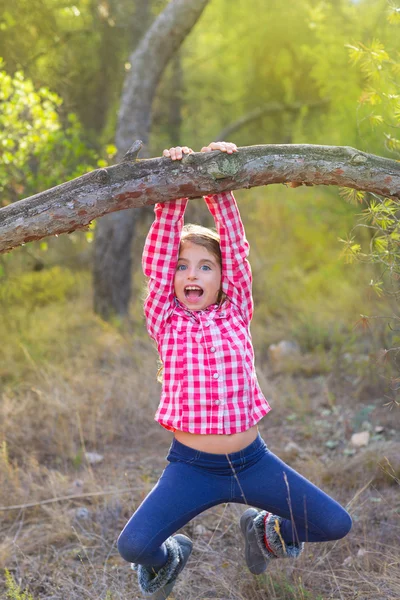 Crianças menina balançando em um tronco na floresta de pinheiros — Fotografia de Stock