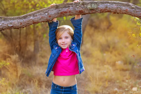 Kinderen meisje swingend in een stam in dennenbos — Stockfoto