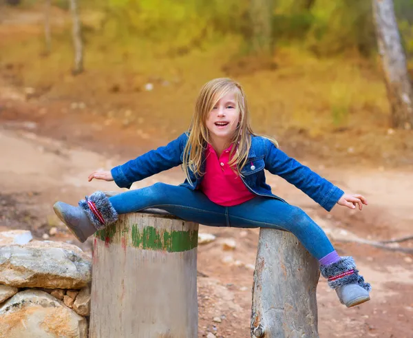 Open benen kinderen meisje of boom boomstammen bij forest — Stockfoto