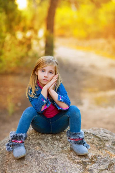 Blond liten flicka fundersam i skogen utomhus sammanträdet — Stockfoto