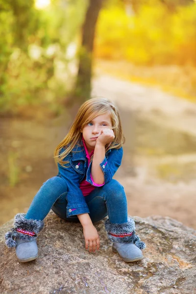 Ragazzina bionda pensierosa annoiata nella foresta all'aperto — Foto Stock