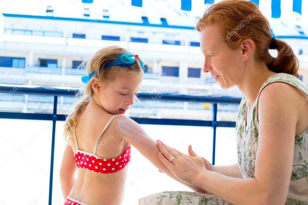Children girl with mother applying sunscreen