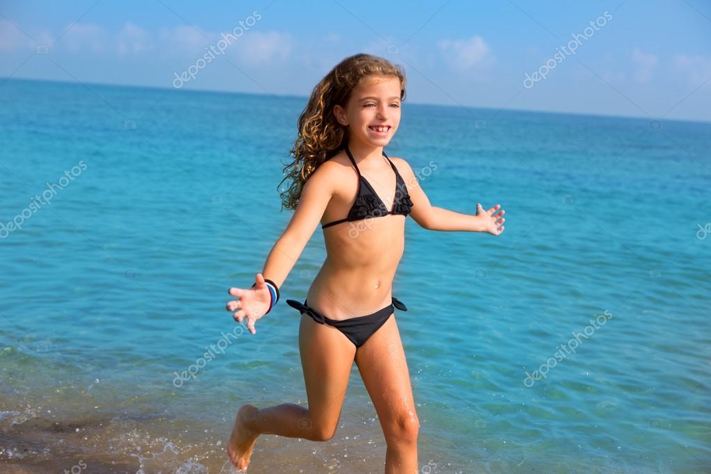 Blue beach kid girl with bikini jumping and running — Stock Photo