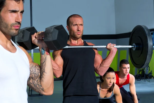 Grupo de ginásio com levantamento de peso bar crossfit treino — Fotografia de Stock