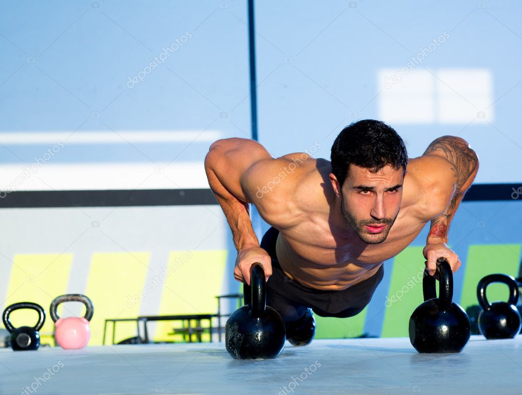 Gym man push-up strength pushup with Kettlebell