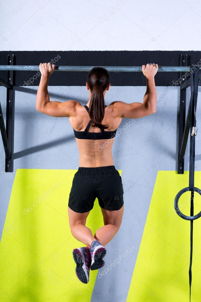Crossfit toes to bar woman pullups 2 bars workout Stock Photo by