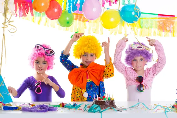 Niños feliz fiesta de cumpleaños con pelucas de payaso —  Fotos de Stock