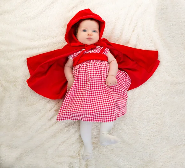 Baby little red riding hood på vit päls — Stockfoto