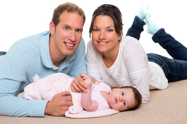 Mãe bebê e pai família feliz deitado no tapete — Fotografia de Stock