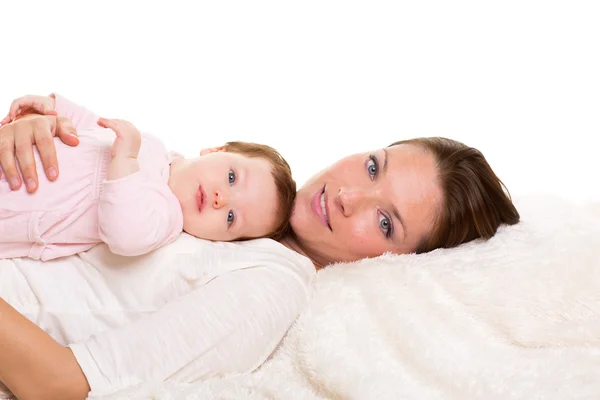 Meisje van de baby en moeder samen gelukkig liggend op witte vacht — Stockfoto