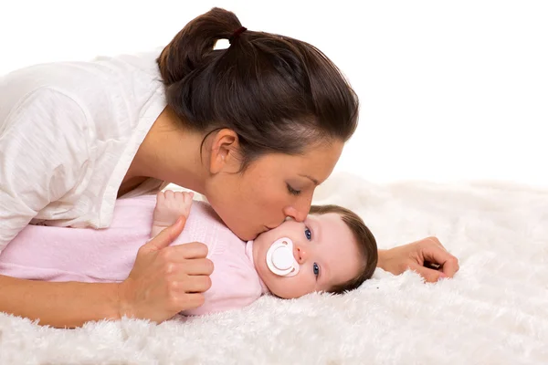 Mädchen und Mutter liegen glücklich zusammen und spielen — Stockfoto