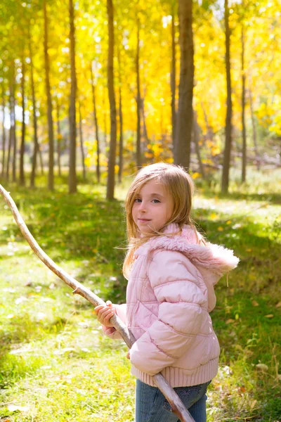 拿着棍子在杨树黄色秋天的森林资源管理器中女孩 — 图库照片