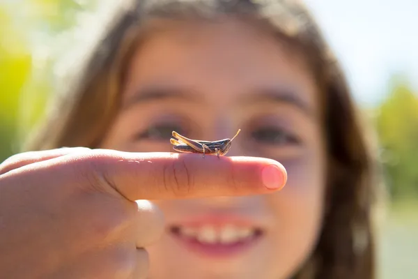 Kid hand met sprinkhaan insect macro — Stockfoto