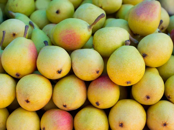 Päron frukter staplade i rad på marknaden — Stockfoto