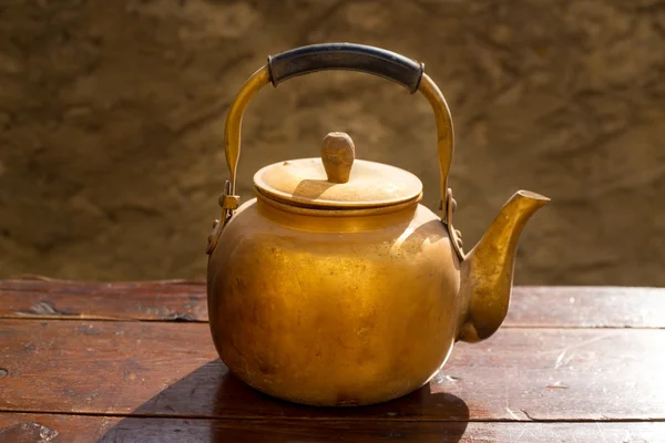 Antique brass teapot on vintage wood table — Stock Photo, Image