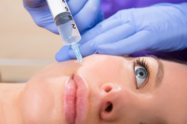 yüz MEZOTERAPİSİ şırınga kadının yüzünde anti-aging