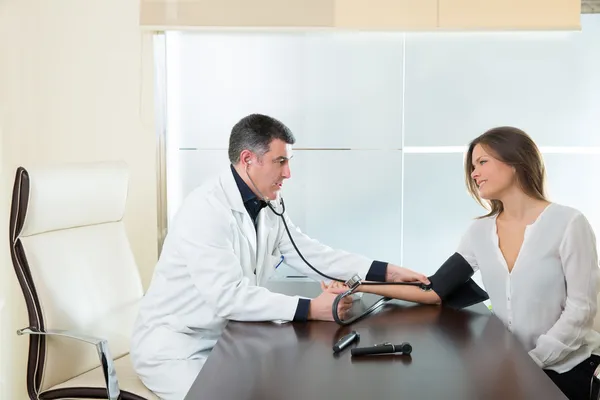 Doctor hombre comprobar presión arterial manguito en mujer paciente — Foto de Stock