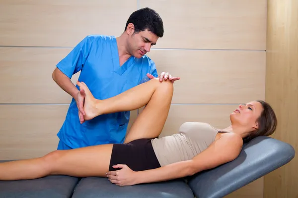 Thérapie de mobilisation de la hanche par le physiothérapeute à la patiente — Photo