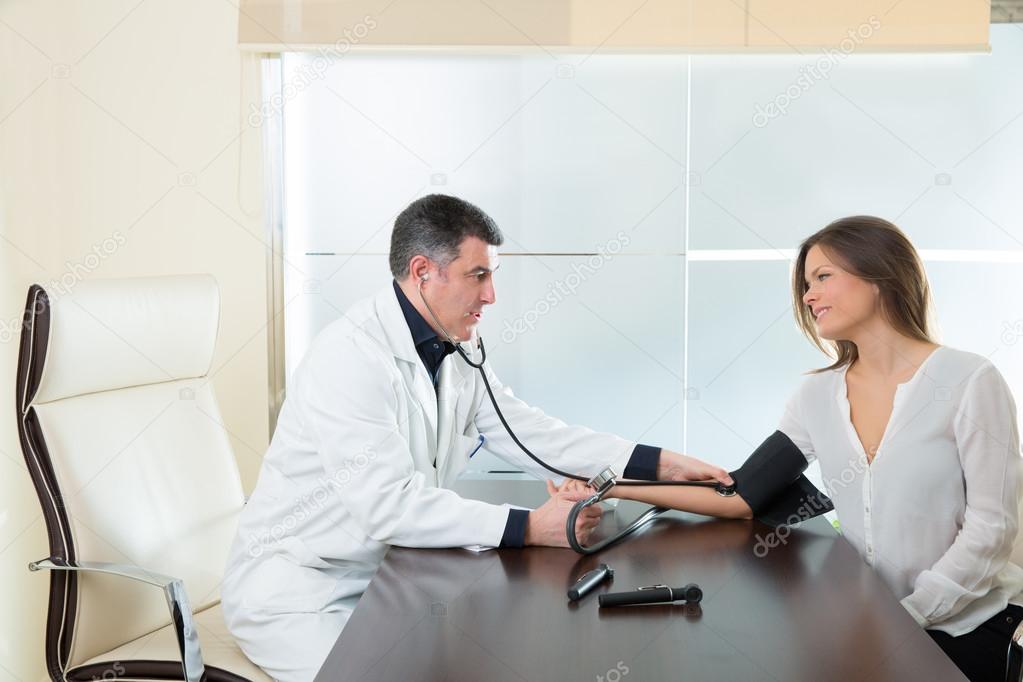 Doctor man checking blood pressure cuff on woman patient