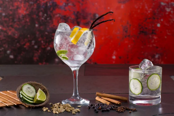 Gin tonic koktél-piros grunge háttérben fűszerek — Stock Fotó