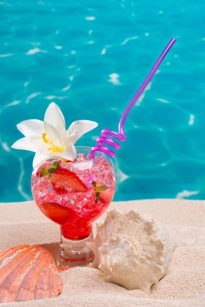 Cocktail de morango em areia de praia com conchas — Fotografia de Stock