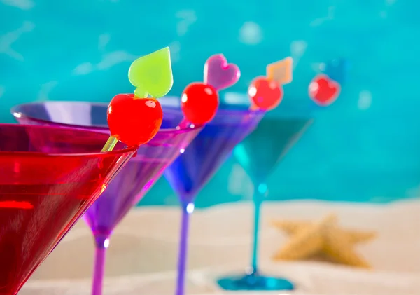 Bunter Cocktail in einer Reihe mit Kirsche am tropischen Sandstrand — Stockfoto