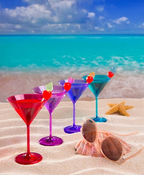 Cocktail coloré dans une rangée avec cerise sur la plage de sable tropical — Photo