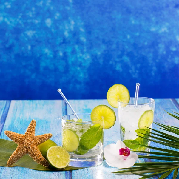 Cóctel cubano Mojito en flores de madera azul tropical y estrellas de mar — Foto de Stock