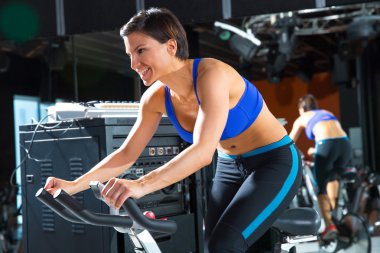 Aerobics spinning monitor trainer woman at gym