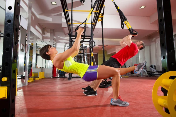 Fitness Ejercicios de entrenamiento TRX en gimnasio mujer y hombre —  Fotos de Stock