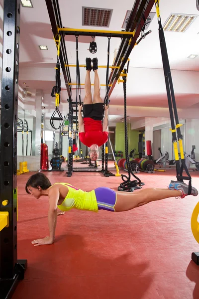 Fitness TRX exercícios de treinamento em mulher ginásio e homem — Fotografia de Stock