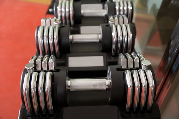 Adjustable weight dumbbells in a row with selective focus — Stock Photo, Image