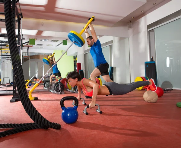 Crossfit mujer flexiones ejercicio y el hombre levantamiento de pesas —  Fotos de Stock