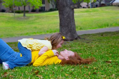 park çim üzerinde yalan oynayan anne ve kızı