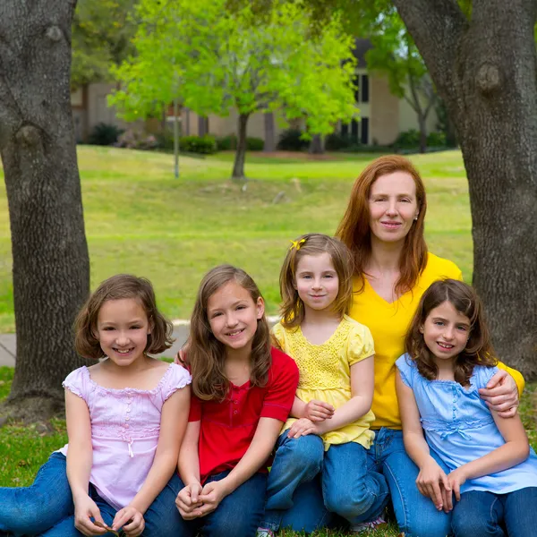 Mother teacher with daughter pupils in playground park — Stock Photo, Image