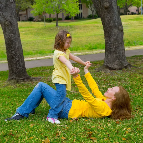 Дочка і мати грають лежачи на парковій галявині — стокове фото
