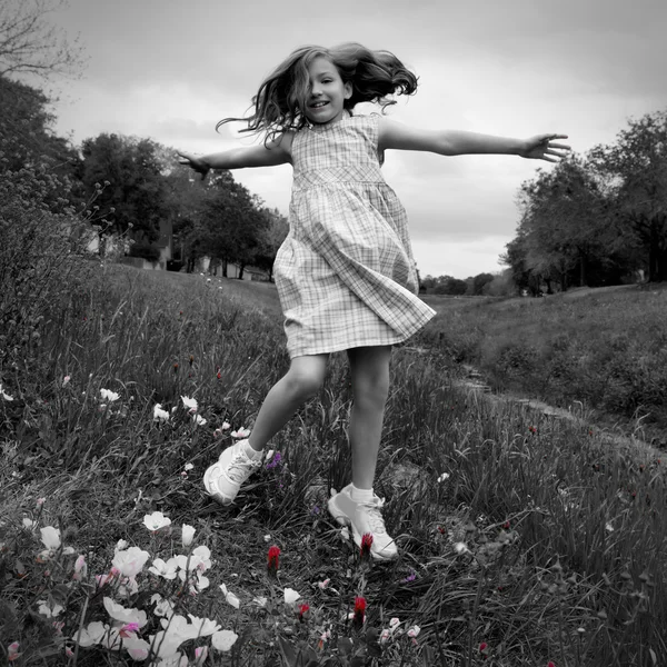 快乐儿童女孩跳上春天罂粟的花朵 — 图库照片