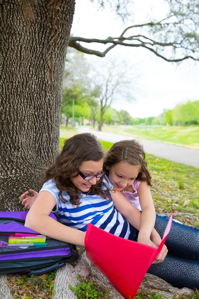 Syster vänner flickor avslappnad under trädet park efter skolan — Stockfoto