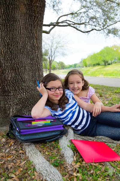 Hermana firends niñas relajado bajo árbol parque después de la escuela —  Fotos de Stock